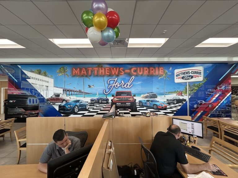 After image of a commercial sign in the vibrant interior of Matthews Currie Ford dealership in Nokomis FL with promotional wall mural