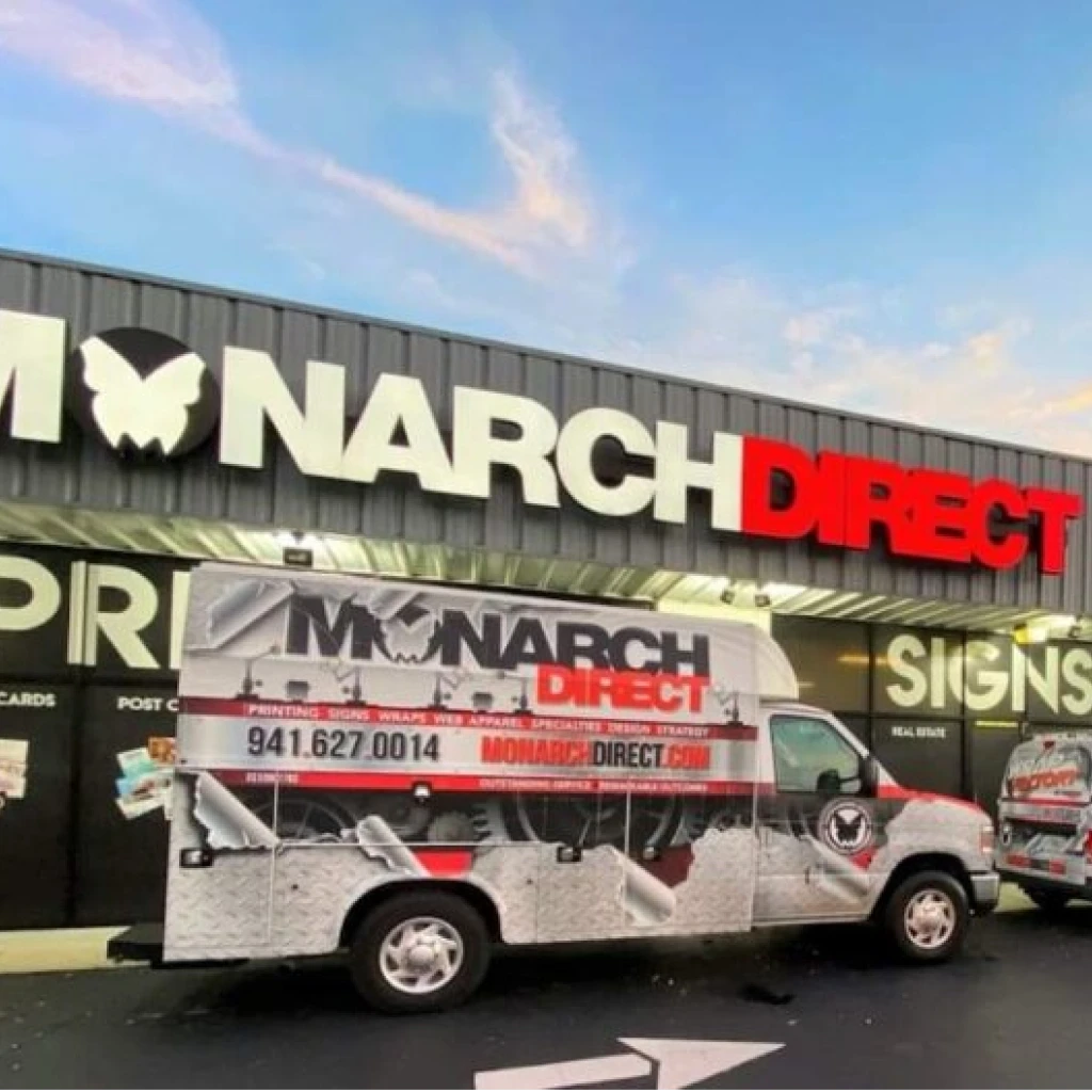 A ‘Monarch Direct’ custom business sign enhancing a vibrant storefront in Port Charlotte.